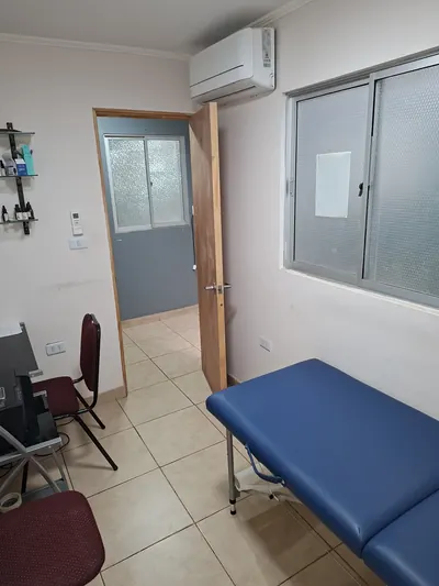 Sala de atención de Centro Relief, con camilla azul y luz de ventana